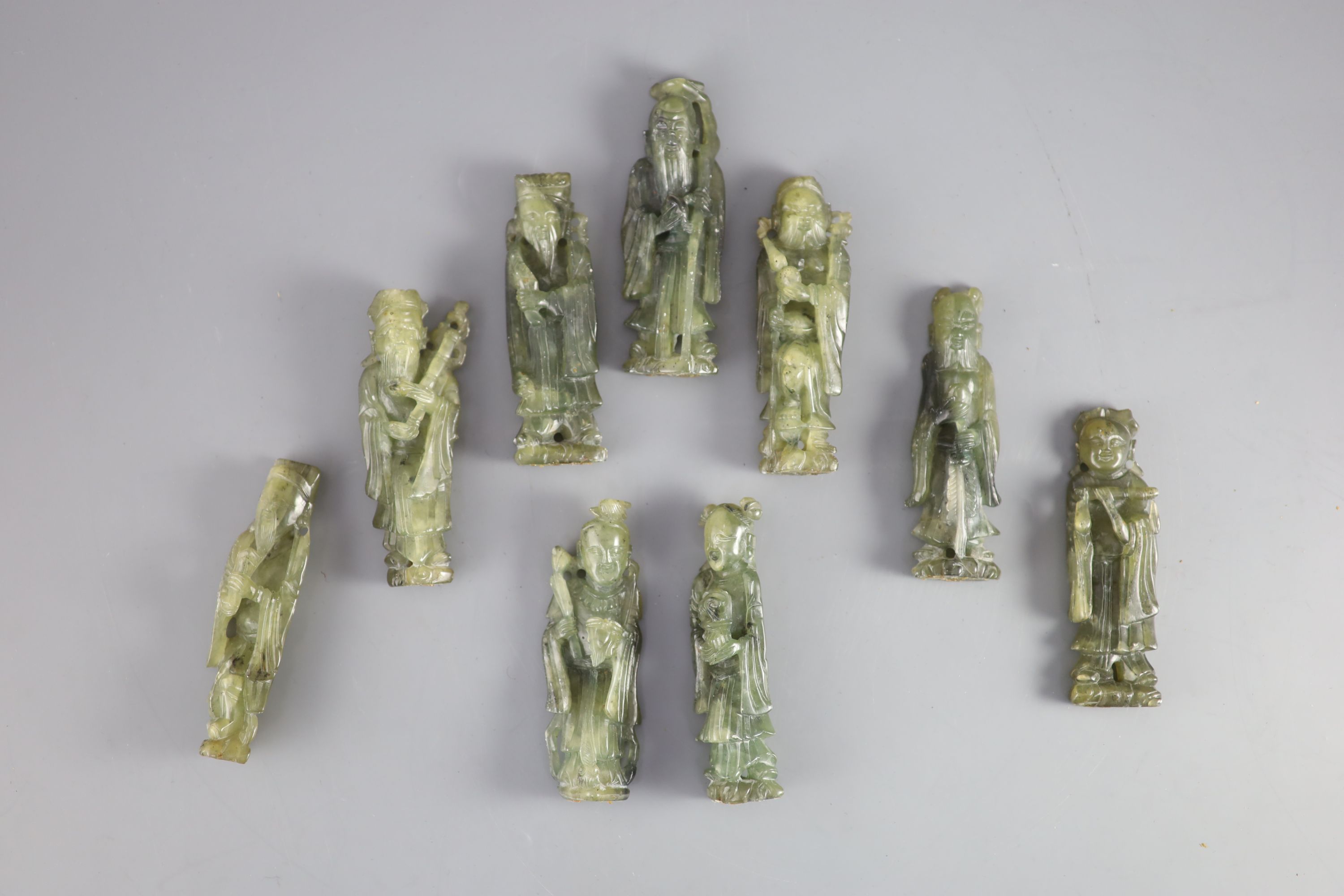 A set of nine Chinese soapstone figures of the Eight Immortals and Shou Lao, on a good zitan two piece rockwork stand, late Qing dyna